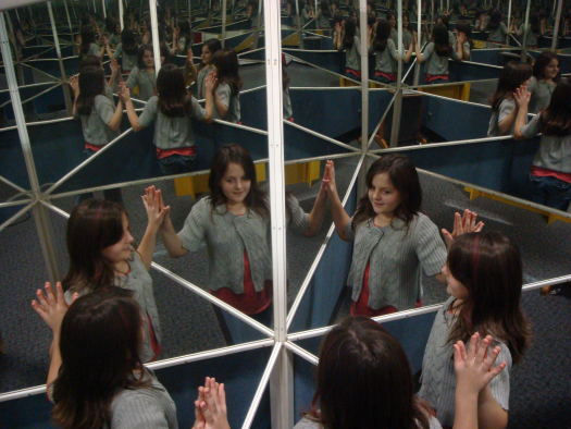 picture of a girl in a hsll of mirrors